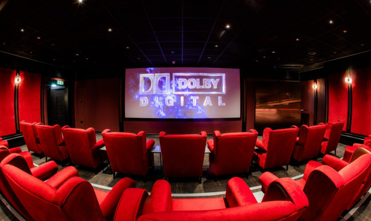 Sala de cinema com poltronas vermelhas no Cameron House Hotel, exemplo de como a tecnologia na hotelaria também se aplica ao entretenimento dos hóspedes.