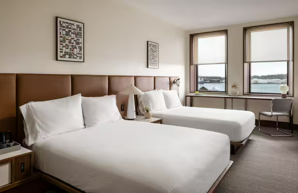 Quarto do Hotel Marcel com janelas amplas e cortinas automatizadas, exemplo de como a tecnologia na hotelaria favorece conforto e eficiência.