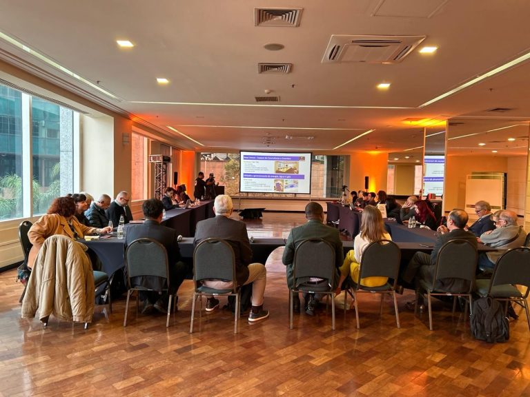 Salão de eventos do Sheraton São Paulo WTC Hotel com participantes sentados em formato de U, assistindo à apresentação técnica do projeto de retrofit tecnológico em hotéis, promovido pela ABIH-SP. Ao fundo, tela exibe informações sobre automação e eficiência energética no setor hoteleiro.