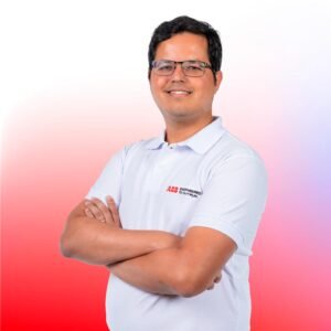 Retrato de Bruno Hessel, um homem de óculos e cabelo escuro, vestindo uma camisa polo branca com o logo da ABB. Ele está sorrindo levemente, de braços cruzados, e o fundo tem um gradiente de cores que vai do vermelho ao branco e ao azul claro.