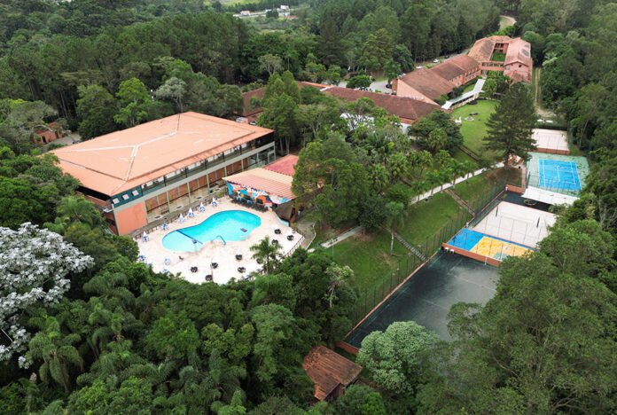 Vista aérea do Terras Altas Resort & Convention Center, complexo hoteleiro cercado por natureza com piscina, quadras de tênis e infraestrutura para eventos.