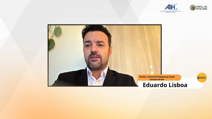 Captura de tela do webinar realizado com Eduardo Lisboa, diretor comercial da Guest Solution Brasil, vestindo paletó escuro e camisa social branca. No canto superior direito, aparecem as marcas da ABIH-SP e do Portal do Hoteleiro.