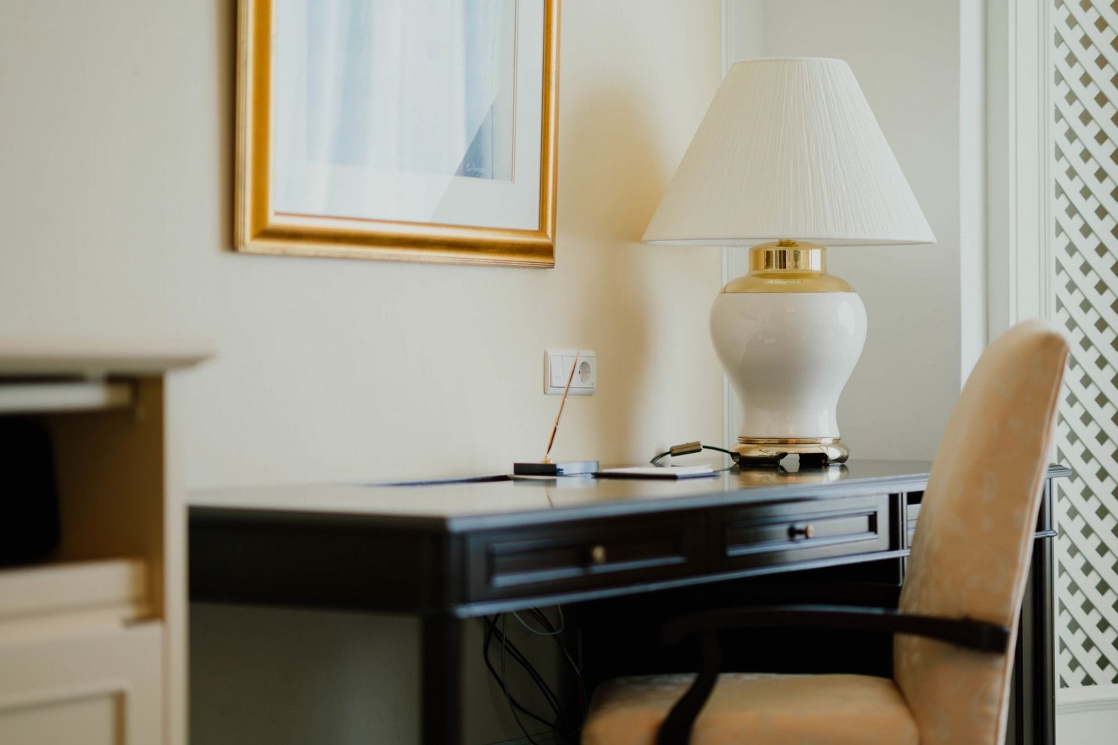 Estação de trabalho aconchegante em quarto de hotel, com mesa espaçosa, cadeira estofada e iluminação suave, ideal para o conforto e a produtividade do room office.