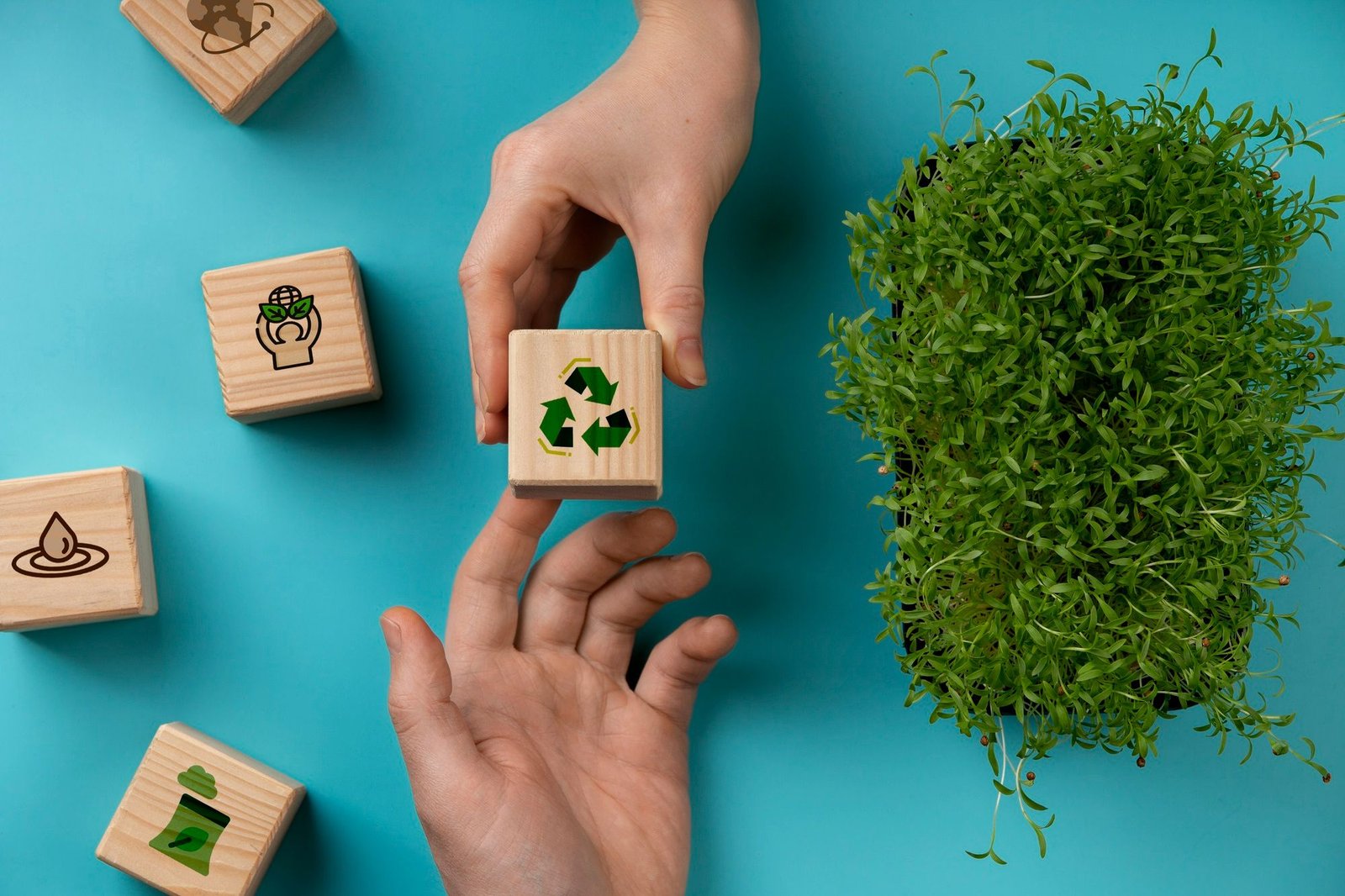 Mão entregando bloco de madeira com símbolo de reciclagem para outra pessoa, ilustrando parcerias do setor de Compras e práticas de sustentabilidade em hotéis.